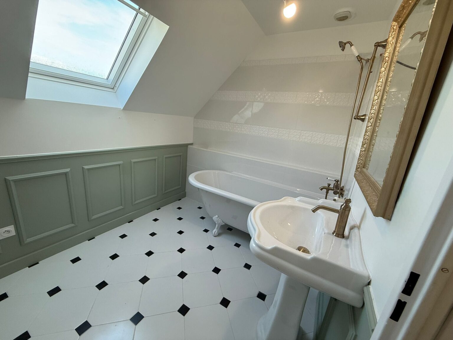 Salle de bain rétro avec baignoire sur pieds et lavabo porcelaine sous fenêtre